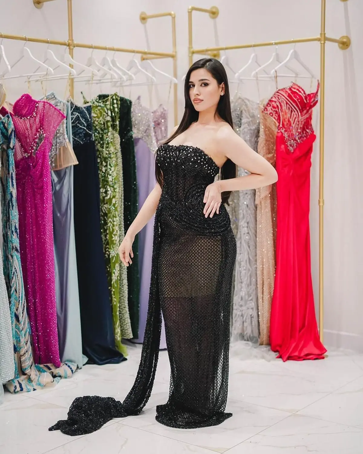 Kleid des V&E-Models, das ein schwarzes Kleid mit Silberstickerei trägt