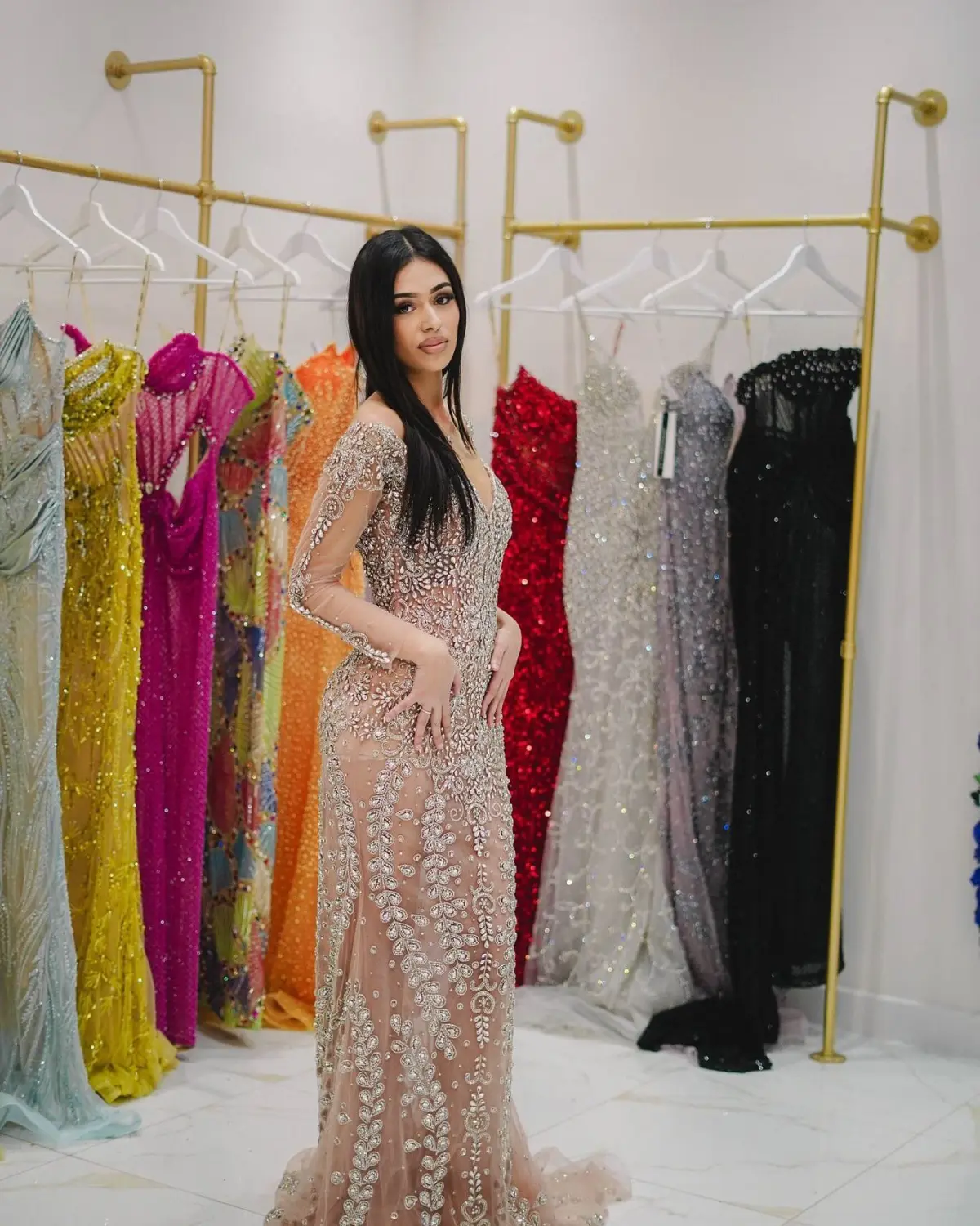 Kleid des V&E-Models, das ein hellbraunes Kleid mit Silberstickerei trägt
